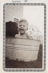 1938, June: Wally F cools off in a classic galvanized tub