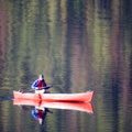 Red canoe in reflections on the lake